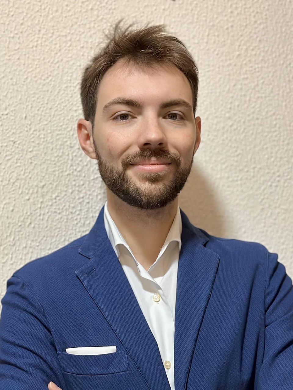 Ritratto: un ragazzo con la barba, in giacca blu e camicia bianca.