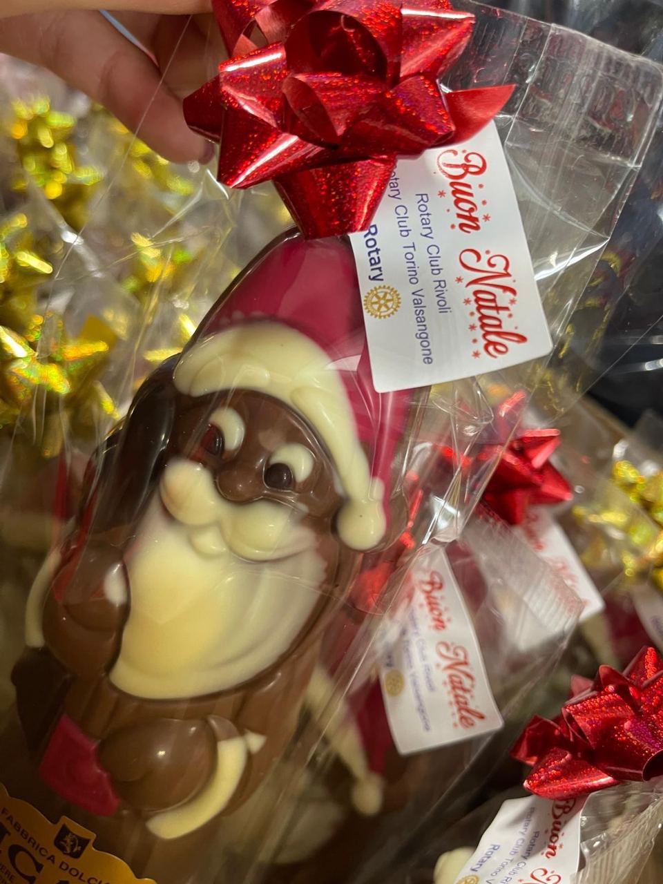 Un Babbo Natale di cioccolato incartato, con il biglietto «Buon Natale» del Rotary Club Rivoli e del Rotary Club Torino Valsangone.